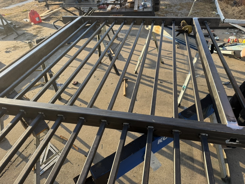 Welded steel fence panels with vertical pickets laid out during fabrication