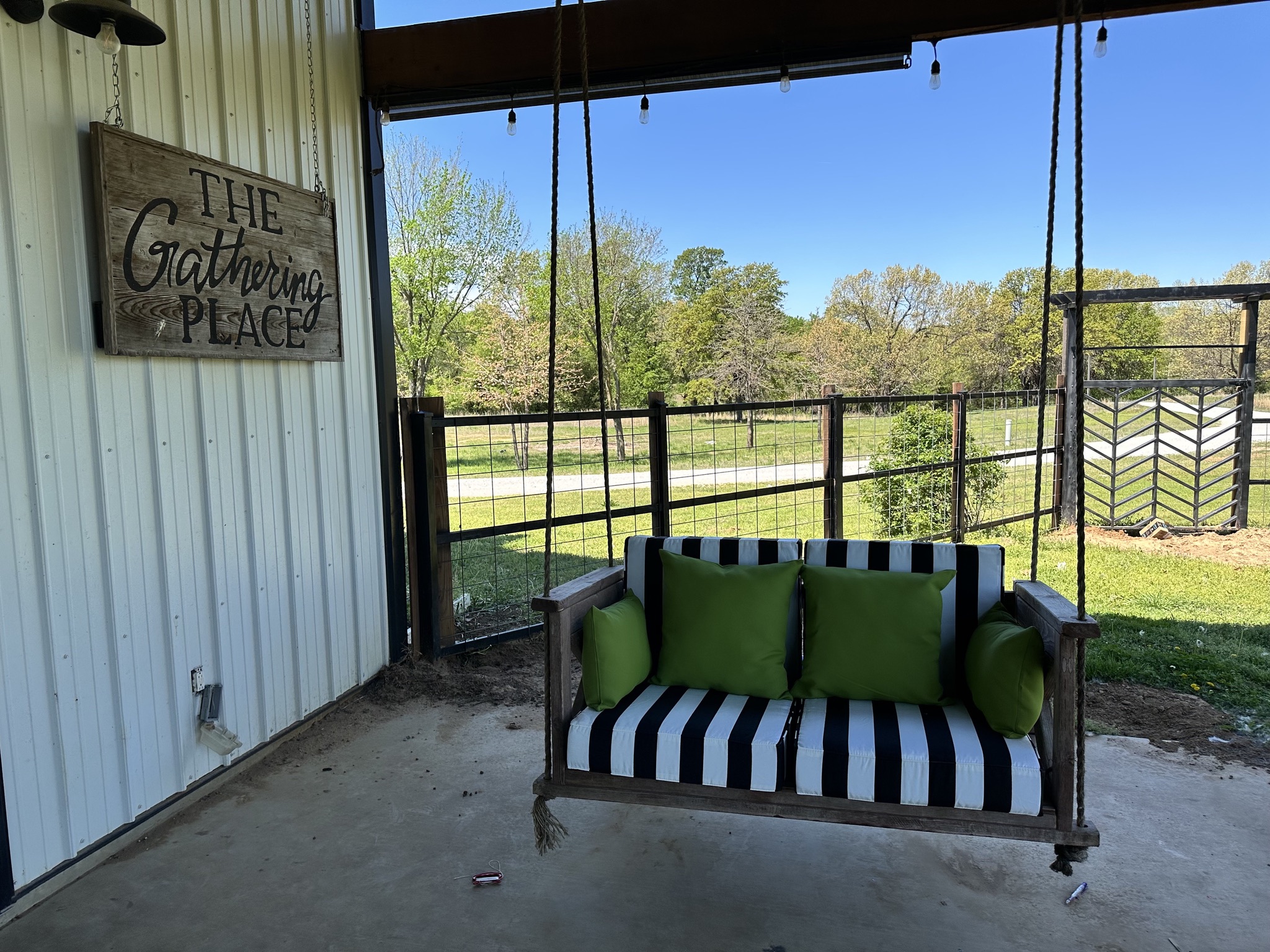 Custom hanging porch swing with steel mounting hardware and cushions on a covered patio