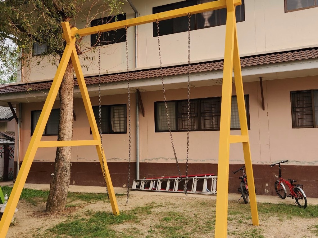 Custom welded yellow steel A-frame swing set with heavy-duty chain and wooden seat